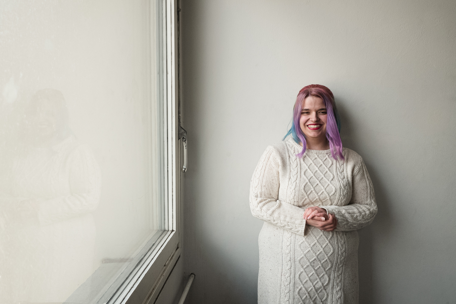 Talent Alice steht an einer Wand neben einem Fenster im Beratungsraum